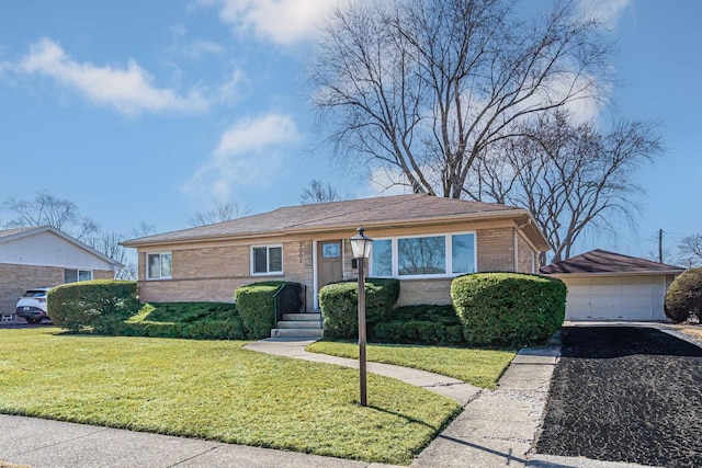 view of front of house featuring a front yard, brick siding, an outdoor structure, and a detached garage