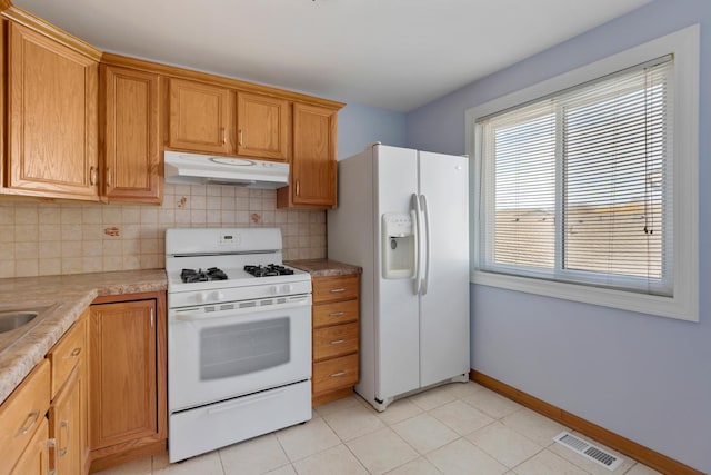 kitchen with white appliances, visible vents, decorative backsplash, light countertops, and under cabinet range hood