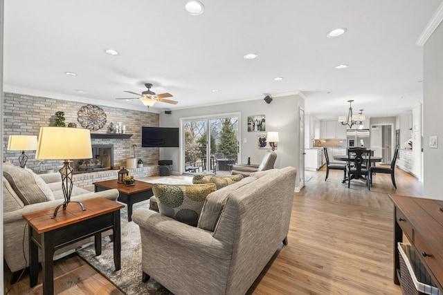 living room with brick wall, ornamental molding, light wood-type flooring, a brick fireplace, and recessed lighting