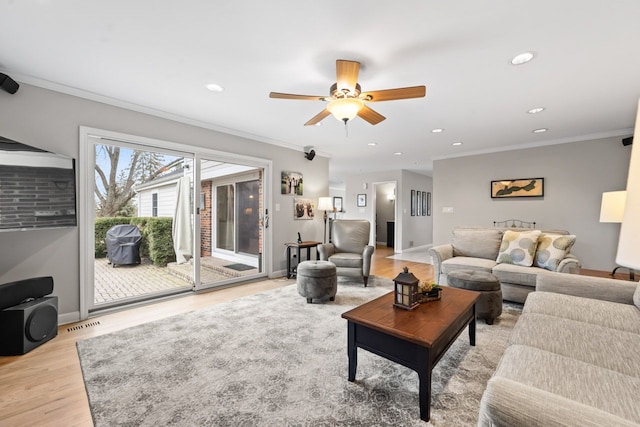 living area with light wood-style floors, baseboards, ornamental molding, and recessed lighting