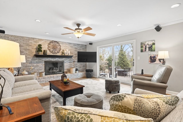 living area with baseboards, brick wall, wood finished floors, crown molding, and a fireplace