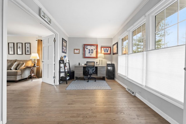 office area featuring visible vents, crown molding, baseboards, and wood finished floors