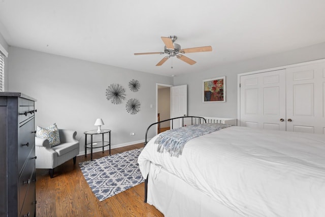 bedroom featuring ceiling fan, a closet, wood finished floors, and baseboards