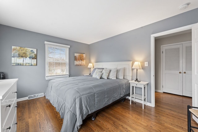 bedroom featuring visible vents, baseboards, and wood finished floors