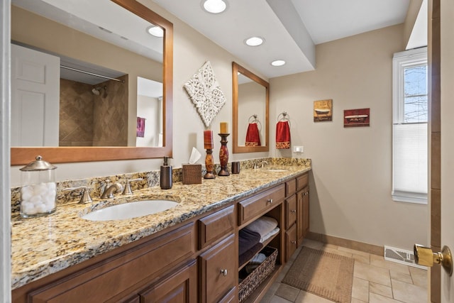 full bath featuring double vanity, recessed lighting, a sink, and baseboards