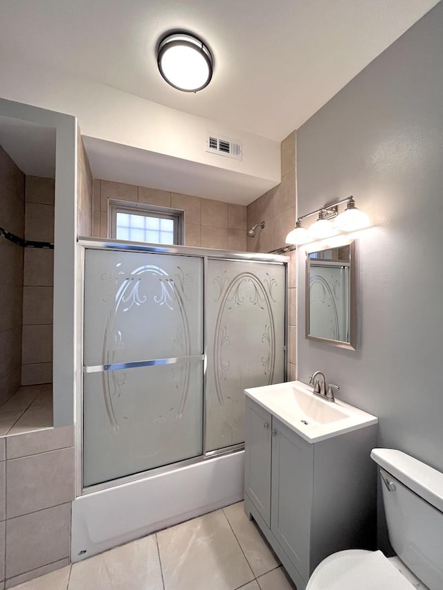 bathroom with enclosed tub / shower combo, toilet, vanity, and visible vents