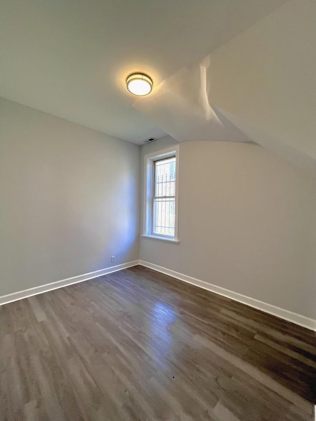 bonus room featuring visible vents, baseboards, and dark wood-style flooring