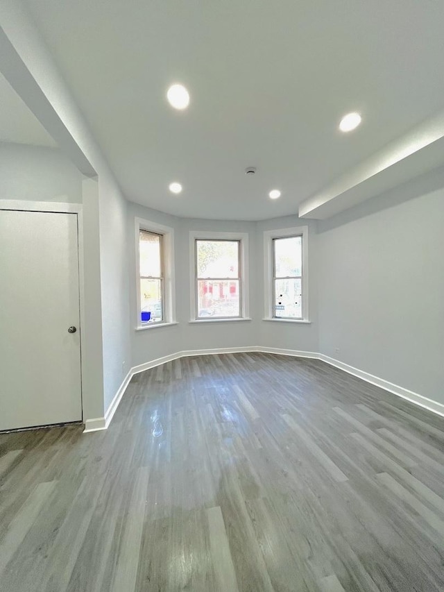 empty room featuring baseboards, wood finished floors, and recessed lighting