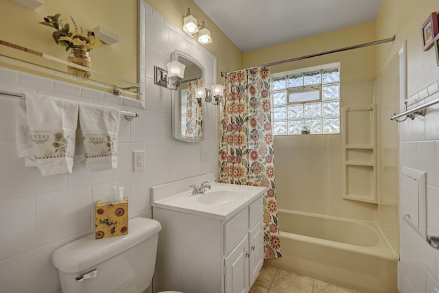 bathroom featuring toilet, tile walls, shower / tub combo with curtain, vanity, and tile patterned flooring