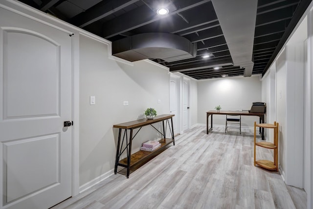 finished below grade area with baseboards and wood finished floors