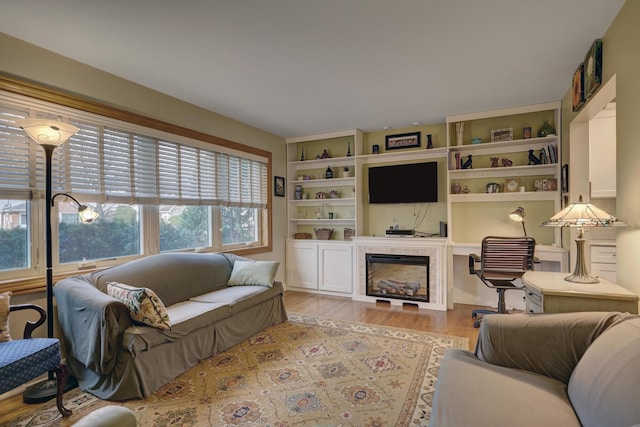 living area with a tiled fireplace and light wood finished floors