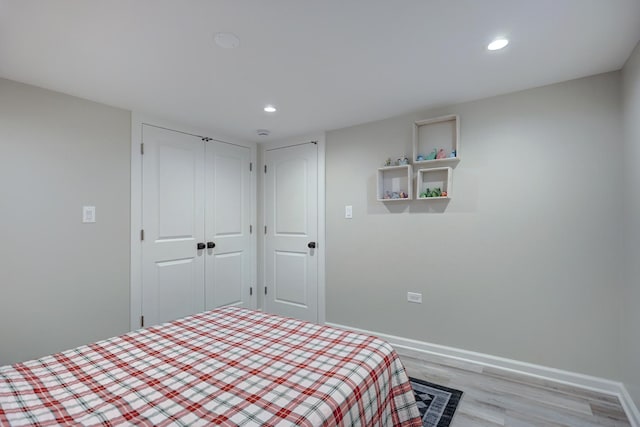bedroom featuring baseboards, light wood-type flooring, and recessed lighting