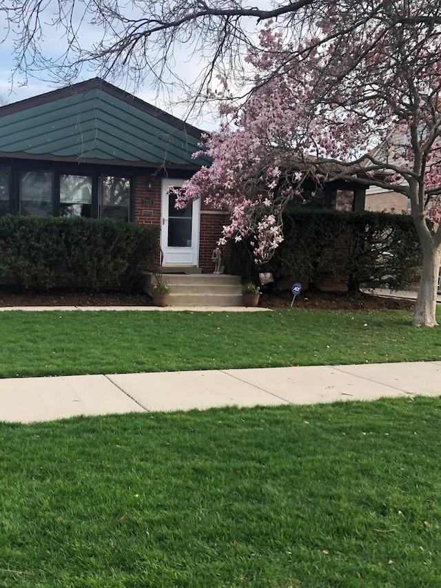 view of front of property with brick siding and a front lawn