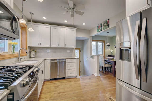 kitchen featuring recessed lighting, white cabinets, ceiling fan, stainless steel appliances, and a sink