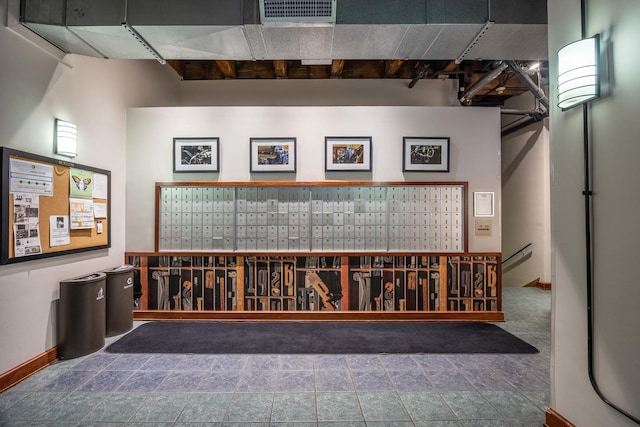 interior space featuring baseboards, mail area, and visible vents