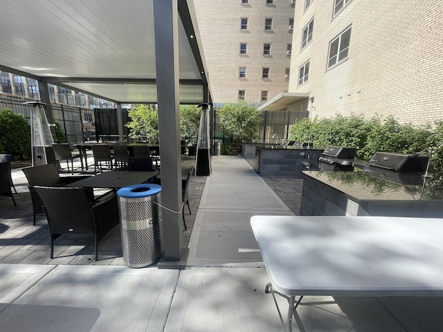 view of patio with outdoor dining area, grilling area, an outdoor kitchen, and fence