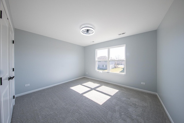 carpeted empty room featuring visible vents and baseboards