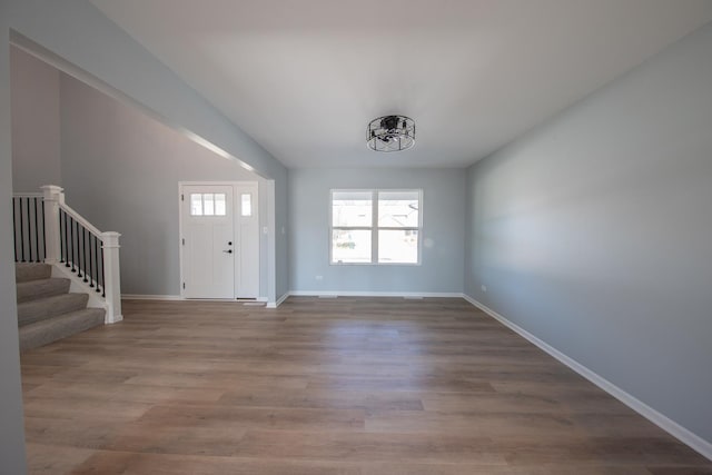 entrance foyer featuring stairs, baseboards, and wood finished floors