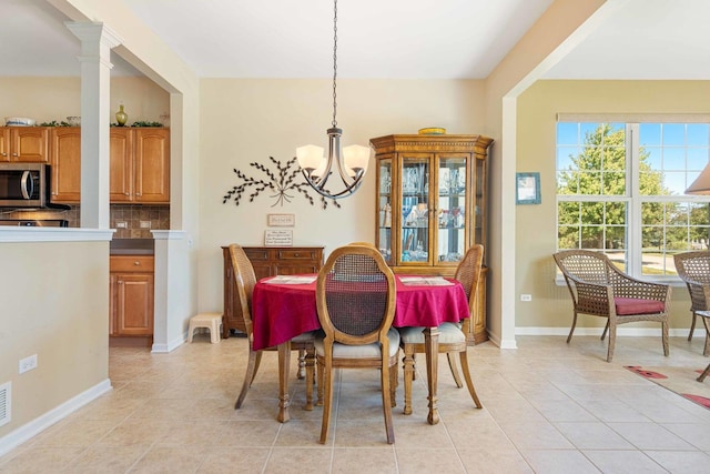 dining area with a chandelier, light tile patterned flooring, and baseboards