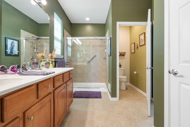 full bathroom featuring double vanity, toilet, a sink, a shower stall, and tile patterned flooring