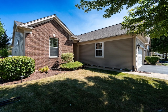 view of front of home with an attached garage, brick siding, a shingled roof, driveway, and a front yard