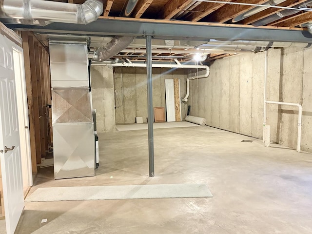 unfinished basement featuring heating unit