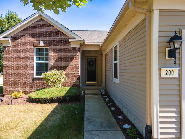 view of exterior entry featuring brick siding