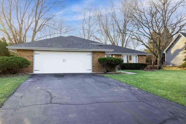 ranch-style house featuring aphalt driveway, brick siding, and a front lawn