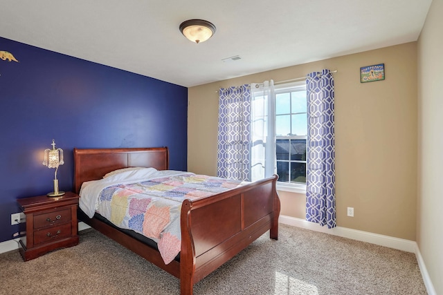 carpeted bedroom featuring baseboards and visible vents