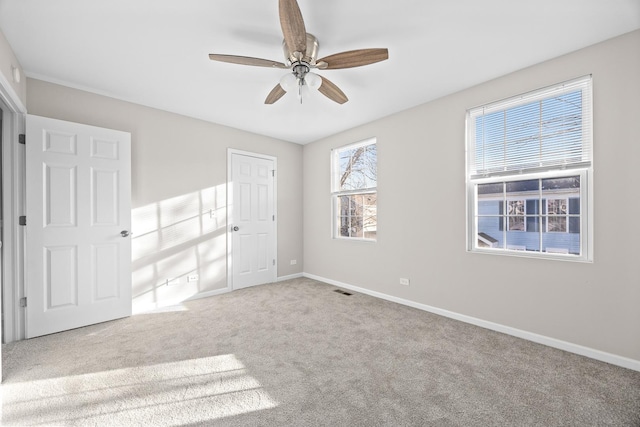 unfurnished bedroom featuring carpet, visible vents, baseboards, and a ceiling fan