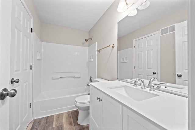 bathroom with shower / washtub combination, visible vents, toilet, vanity, and wood finished floors