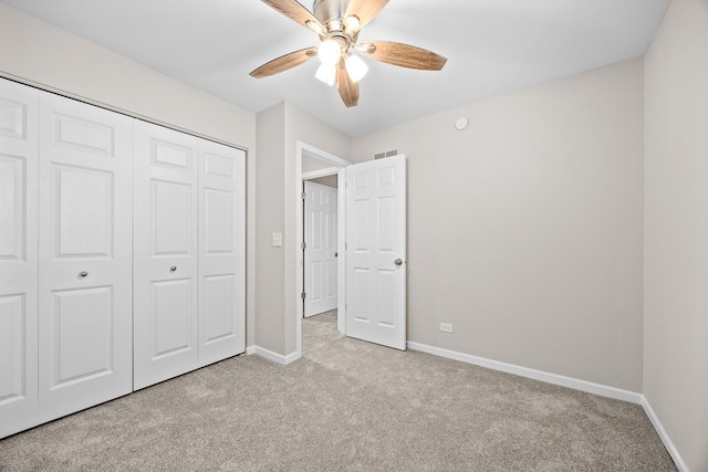 unfurnished bedroom featuring light carpet, a closet, visible vents, and baseboards