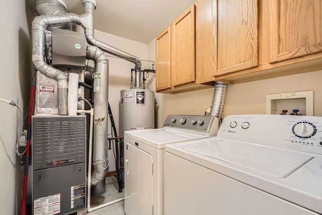 washroom with washing machine and dryer, cabinet space, and water heater