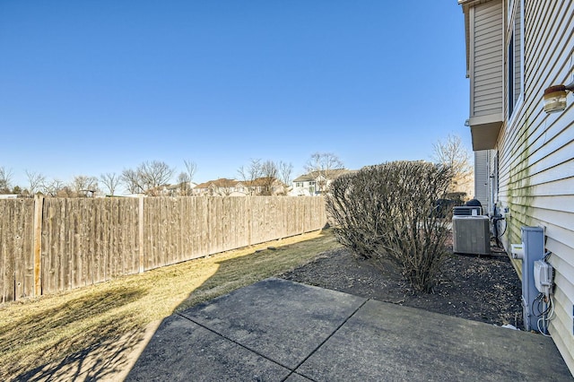 view of yard with a patio area, fence, and central air condition unit