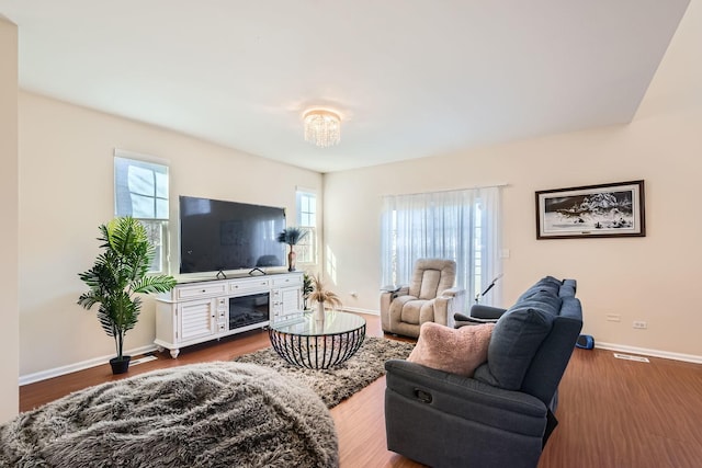 living area with baseboards and wood finished floors