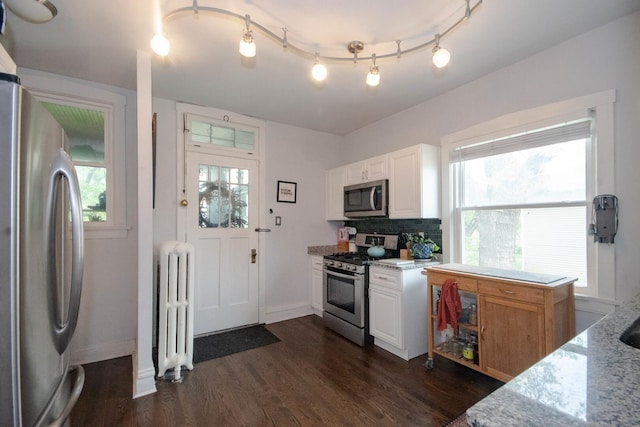 7940 S Oglesby Ave, Chicago, IL 60617 - kitchen with stainless steel appliances, radiator heating unit, dark wood finished floors, and light stone counters