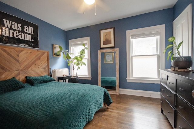 7940 S Oglesby Ave, Chicago, IL 60617 - bedroom with multiple windows, radiator heating unit, wood finished floors, and baseboards