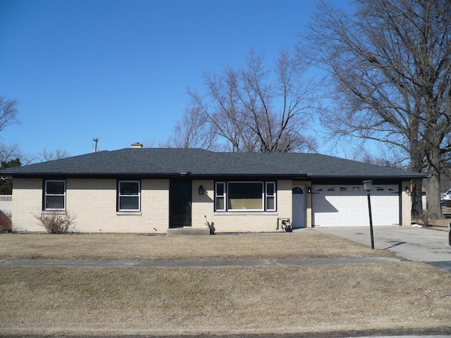 ranch-style home featuring brick siding, driveway, an attached garage, and roof with shingles