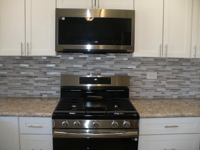 kitchen featuring appliances with stainless steel finishes, white cabinetry, and tasteful backsplash