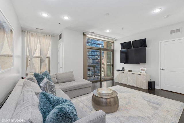 living room with recessed lighting, visible vents, dark wood-style flooring, and baseboards