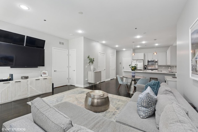 living room with recessed lighting, visible vents, baseboards, and dark wood-style floors