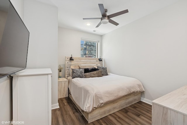 bedroom with dark wood-type flooring, baseboards, visible vents, and ceiling fan