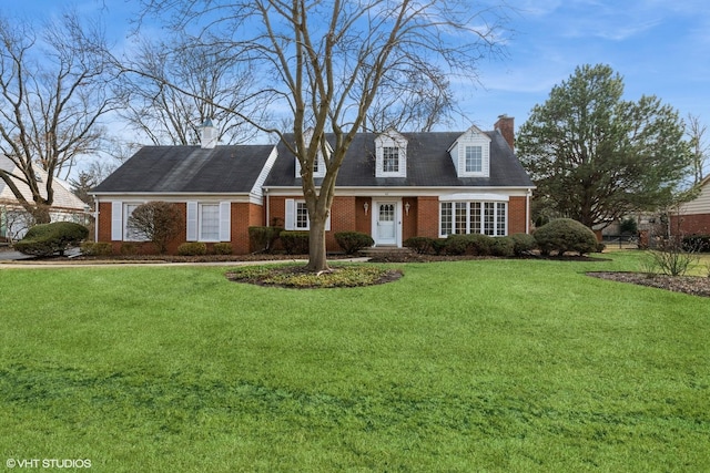 cape cod-style house with a front lawn, a chimney, and brick siding