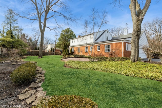 view of yard with an attached garage and fence