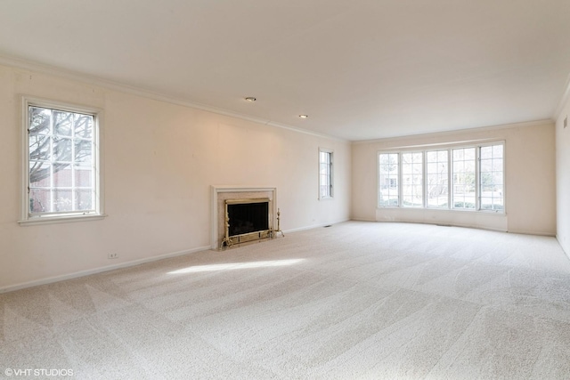 unfurnished living room with baseboards, a fireplace with flush hearth, ornamental molding, and carpet flooring