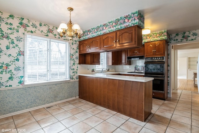 kitchen featuring dobule oven black and wallpapered walls