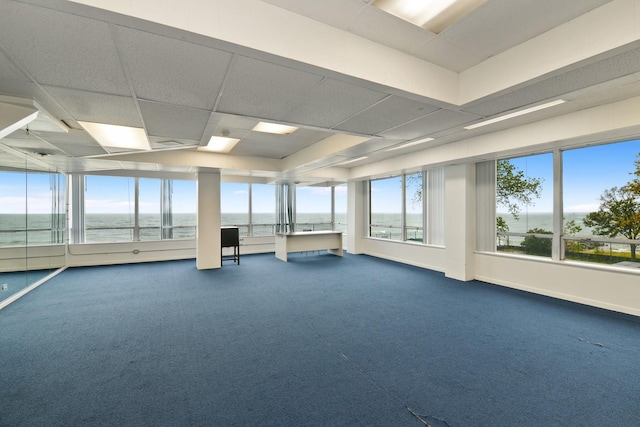 interior space featuring a water view, baseboards, dark colored carpet, and a drop ceiling