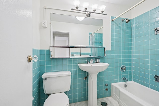 full bath featuring toilet, bathtub / shower combination, tile walls, and tile patterned floors