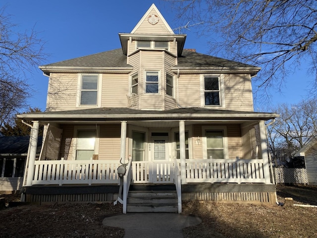 view of front facade with a porch and roof with shingles