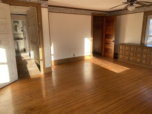 spare room featuring ceiling fan, ornamental molding, a sink, and wood finished floors